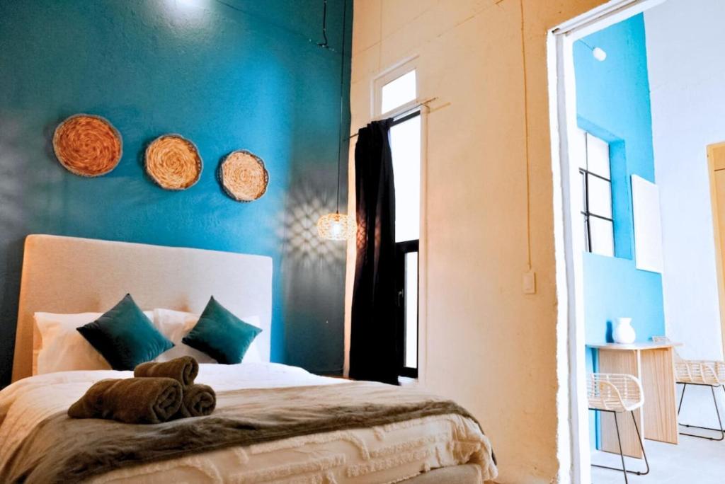 a bedroom with a bed with a blue wall at Bonita Casona enfrente del Santuario 7 G in Guadalajara