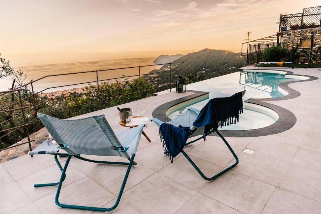 two chairs and a cat sitting on a patio at BLUVARI' Charming House in Alassio