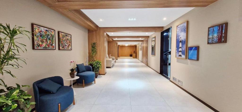 un corridoio in un ospedale con sedie e piante blu di Centro de Convenções - Smart 204 a Salvador