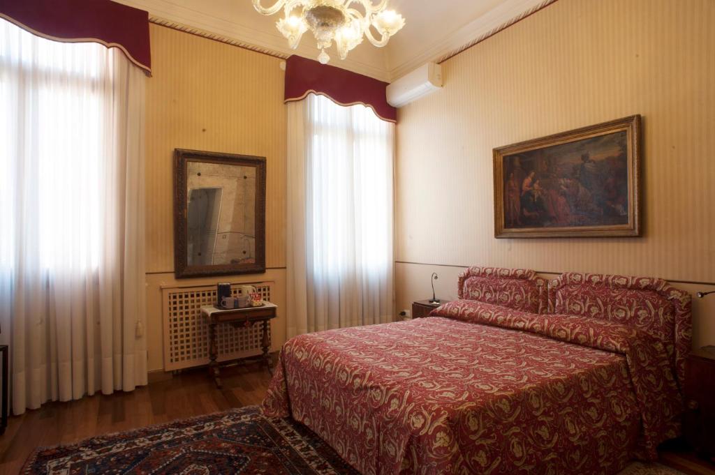 una camera da letto con un letto e un lampadario di Camera doppia con bagno e terrazza a Venezia