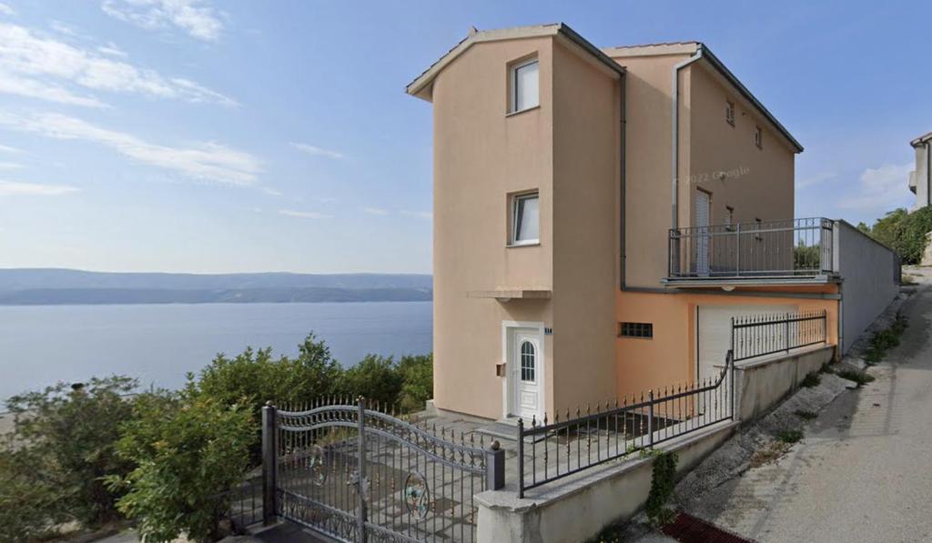 een gebouw met een hek naast een waterlichaam bij Panorama Apartment Marija in Stanići