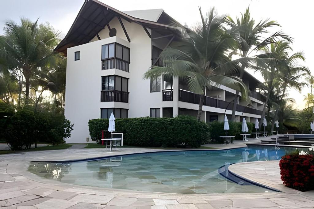 ein Gebäude mit einem Swimmingpool vor einem Gebäude in der Unterkunft Flat no Nannai Residence - Muro Alto in Porto De Galinhas
