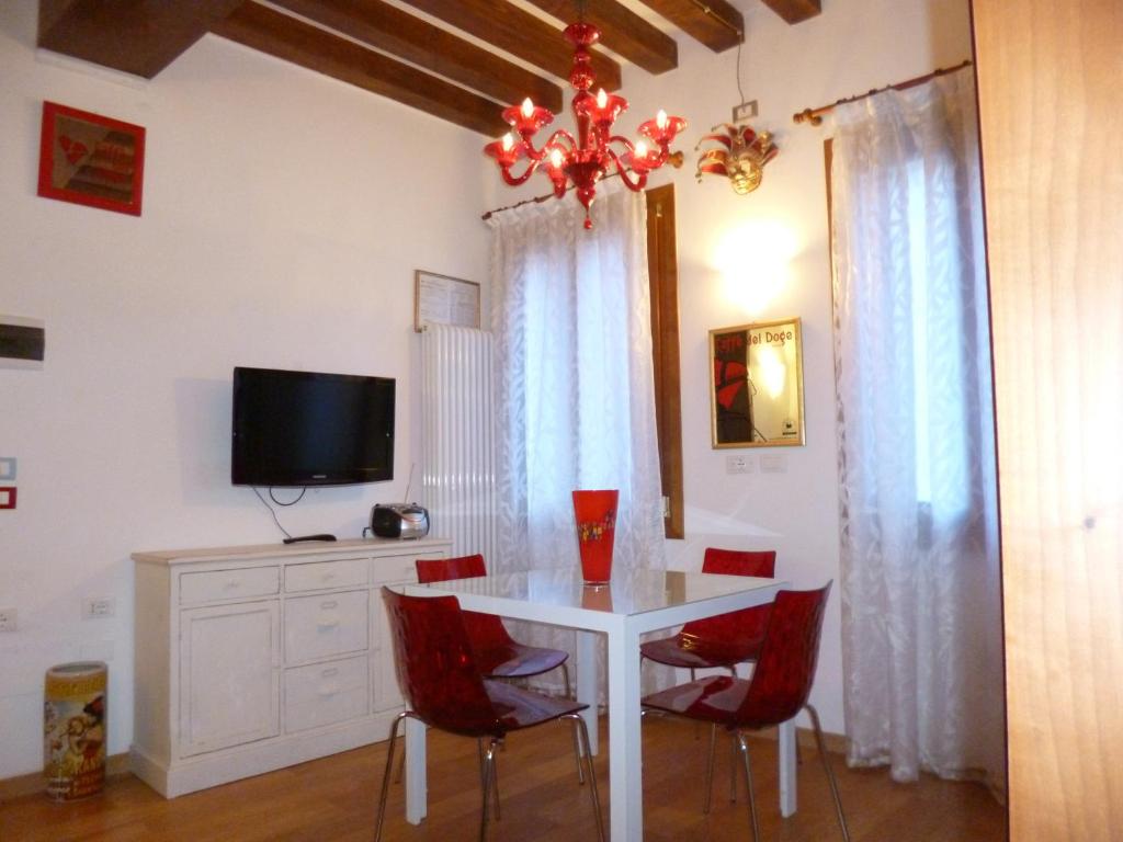 jadalnia z białym stołem i czerwonymi krzesłami w obiekcie Casa Contarina w Wenecji