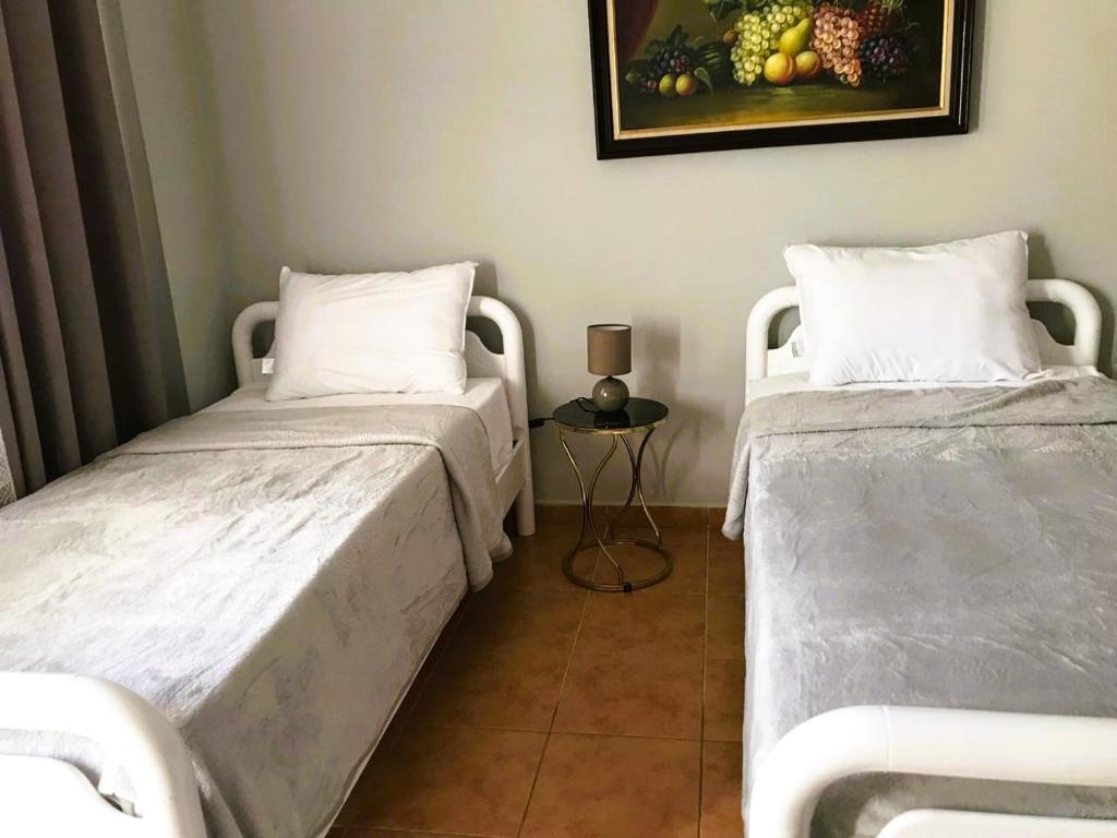 two beds sitting next to each other in a room at Apartmenti Veritos in Berat