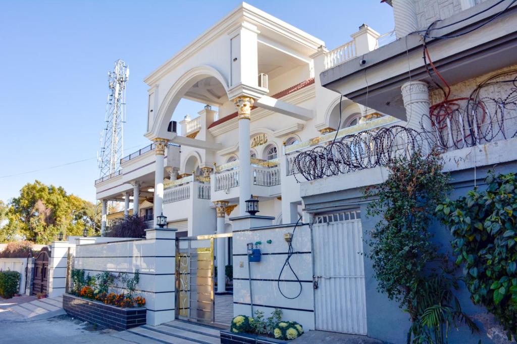 ラーワルピンディーにあるMehmaan Lodgeの門と柵のある白い家