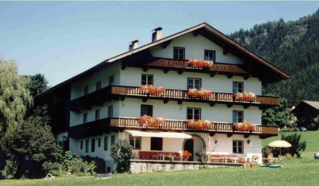 une grande maison avec des fleurs sur les balcons dans l'établissement Maurachbauer, à Stumm