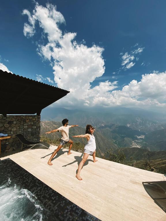 two children are standing on the edge of a swimming pool at Hotel Boutique el Fique in Los Santos