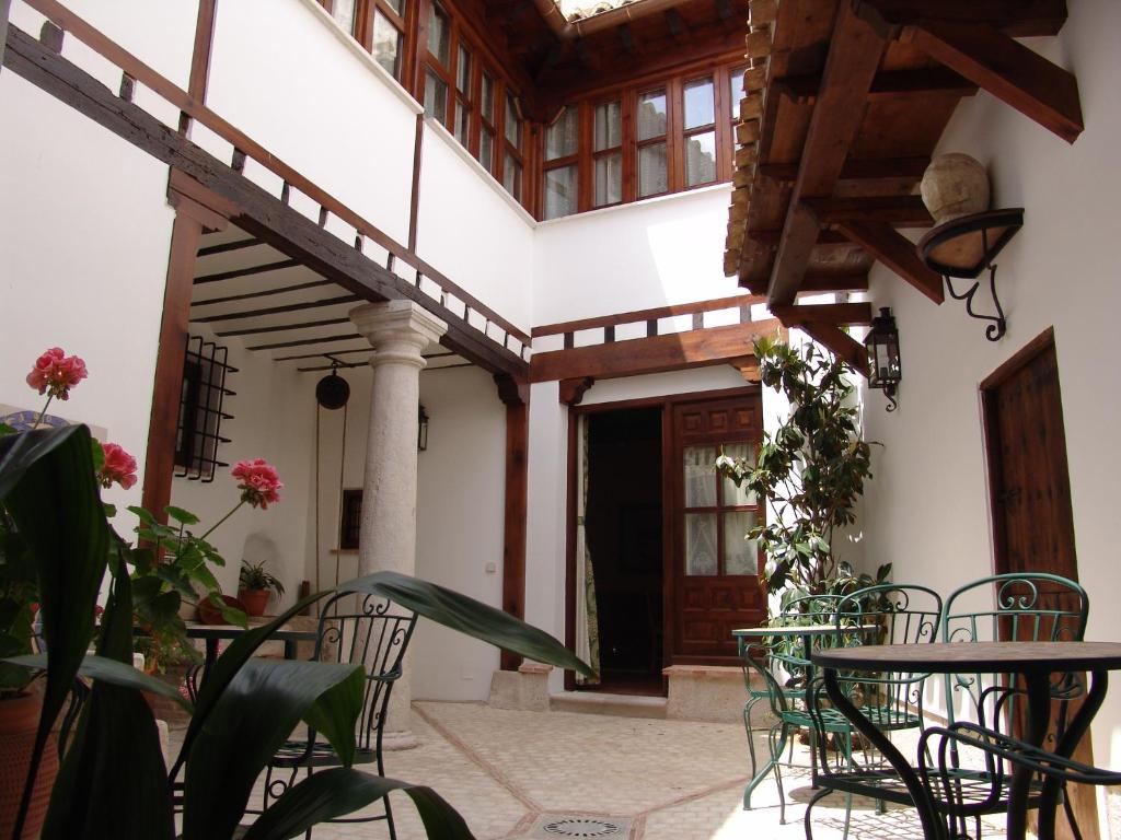 a patio with tables and chairs in front of a building at Apartamentos La Columna in Chinchón