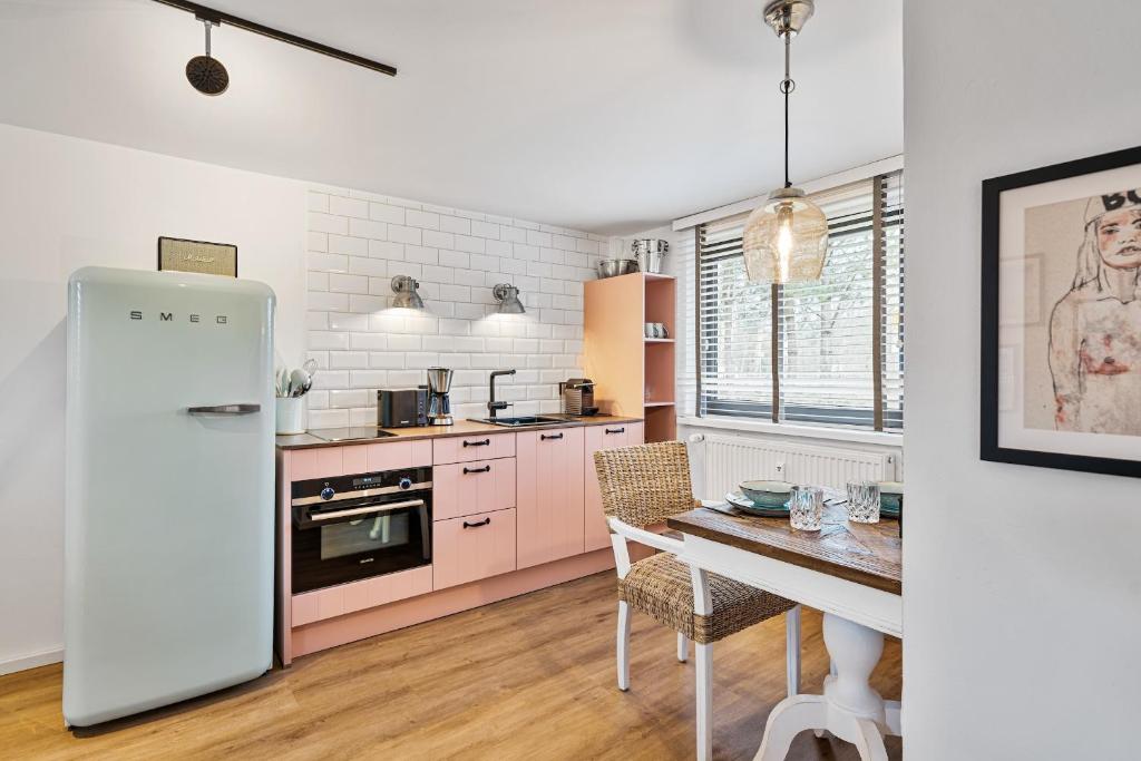 a kitchen with pink appliances and a dining room table at Ankerplatz SPO 2 in Böhl