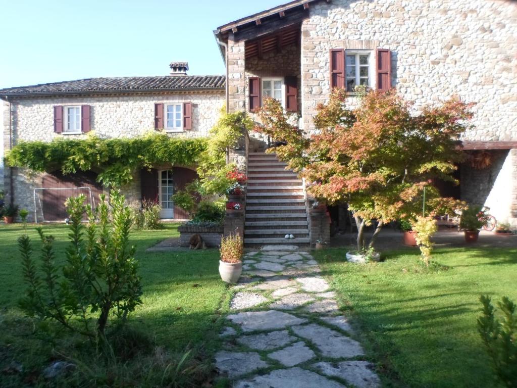 une maison en pierre avec un escalier dans la cour dans l'établissement B&B Le Querce, à Verucchio