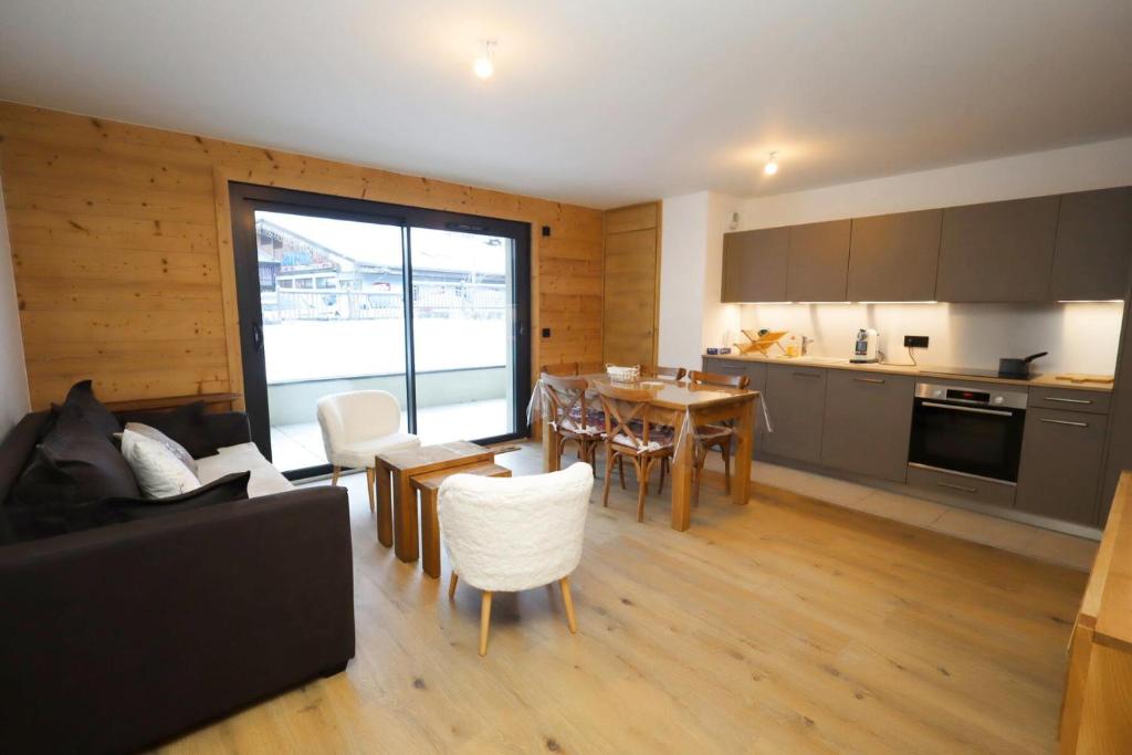 une cuisine et un salon avec une table et des chaises dans l'établissement Résidence Les Cosmiques - Les Cosmiques MAE-6781, aux Houches