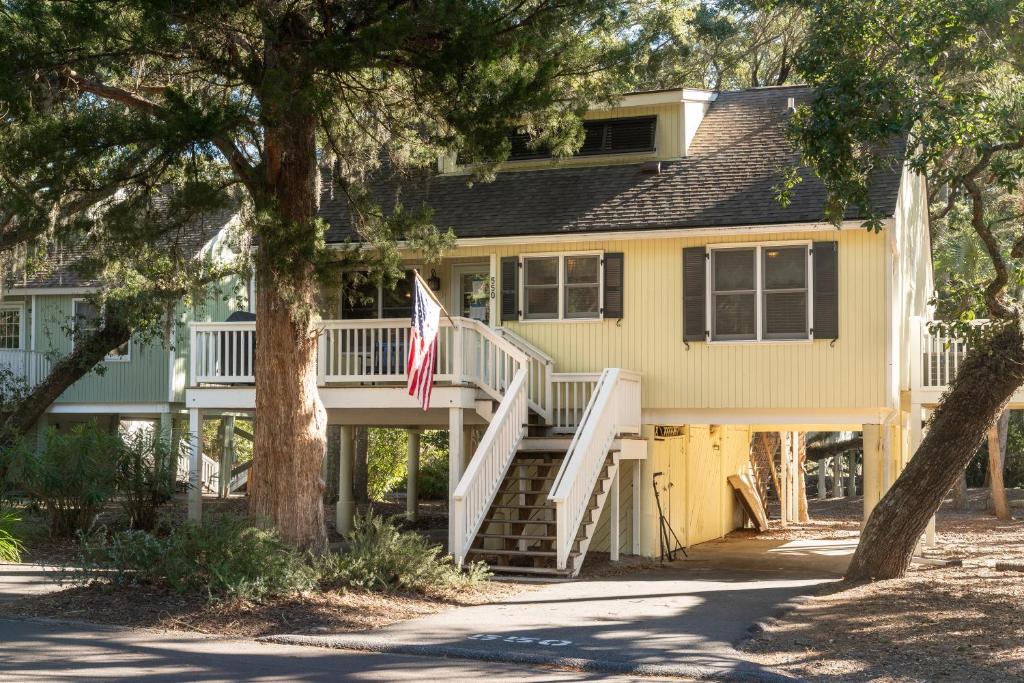 a yellow house with a flag in front of it at 550 Tarpon Pond Cottage in Seabrook Island