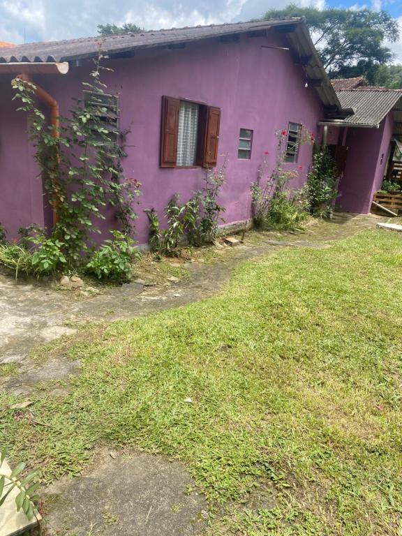 a purple house with a yard in front of it at Casa roxa in Itatiaia