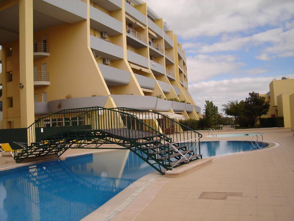 un hotel con piscina al lado de un edificio en Caesar Apartment, en Lagos