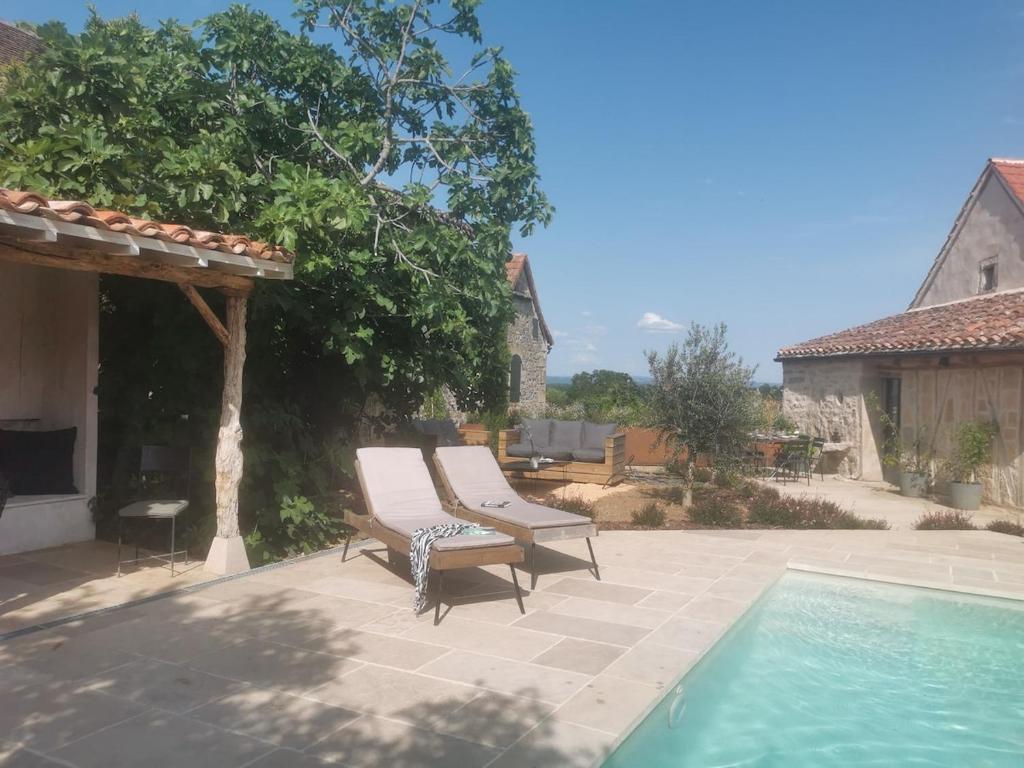 a pair of chairs sitting next to a swimming pool at La Maison Médiévale à colombage en Quercy in Puylagarde
