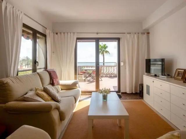 a living room with a couch and a coffee table at Atico la piramide en primera 1º línea de mar in Vinarós