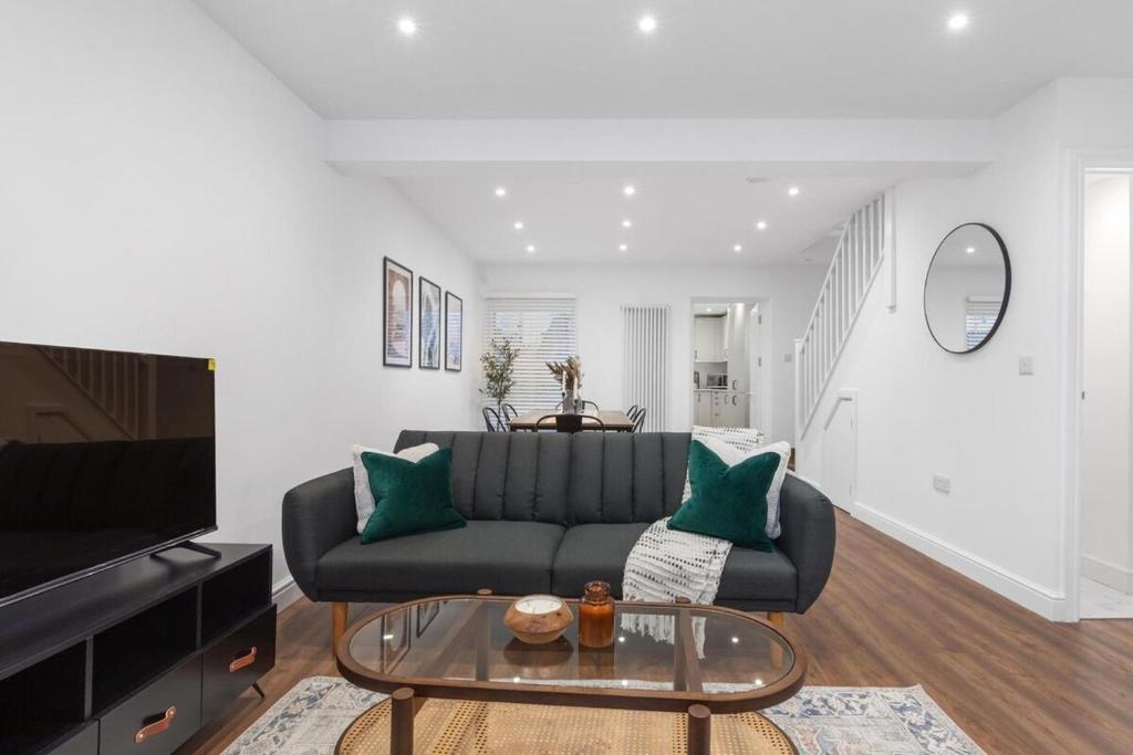 a living room with a couch and a glass table at Furnished Terraced House near Public Attractions, 5 min to Public Transport in Hemel Hempstead