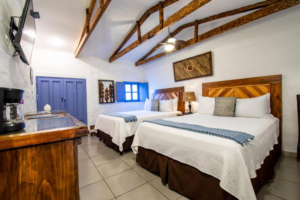 a hotel room with two beds and a kitchen at Hotel Casa Pino, Tu Casa en Ataco in Concepción de Ataco