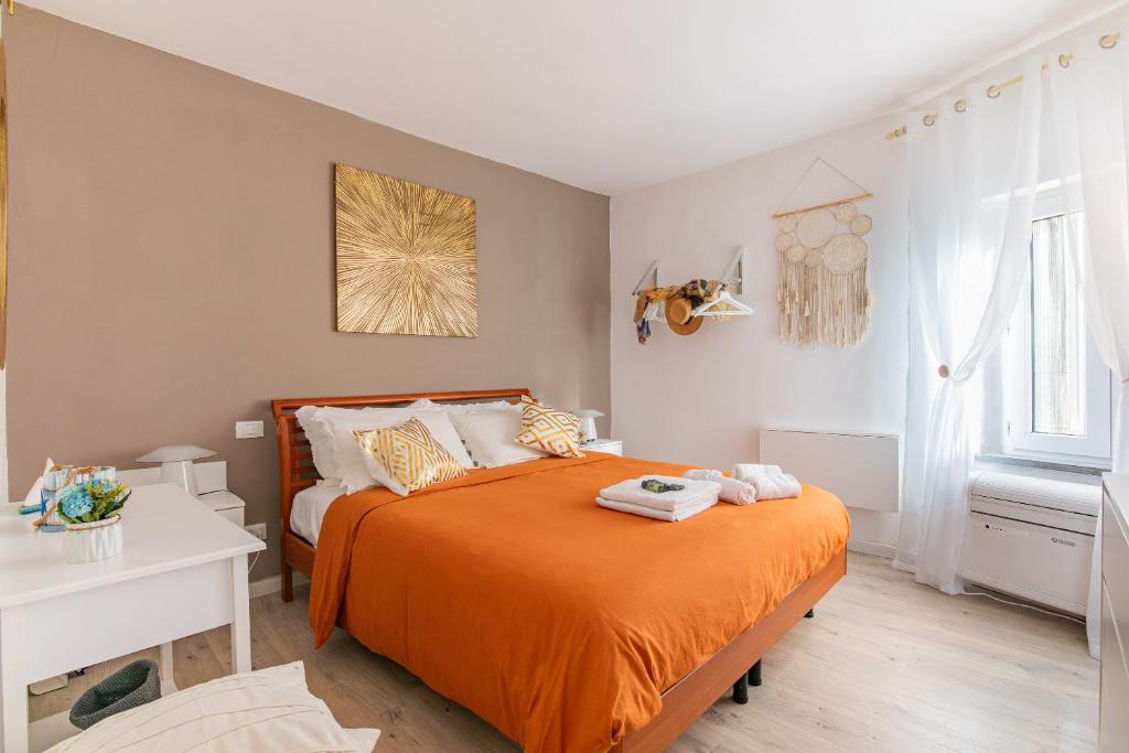 a bedroom with a bed with an orange blanket at Nel Borgo Antico in Riomaggiore