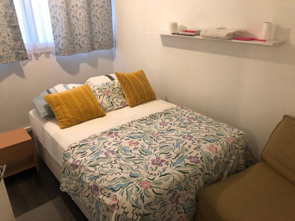 Dormitorio pequeño con cama con edredón en Aso rock, en Dartford