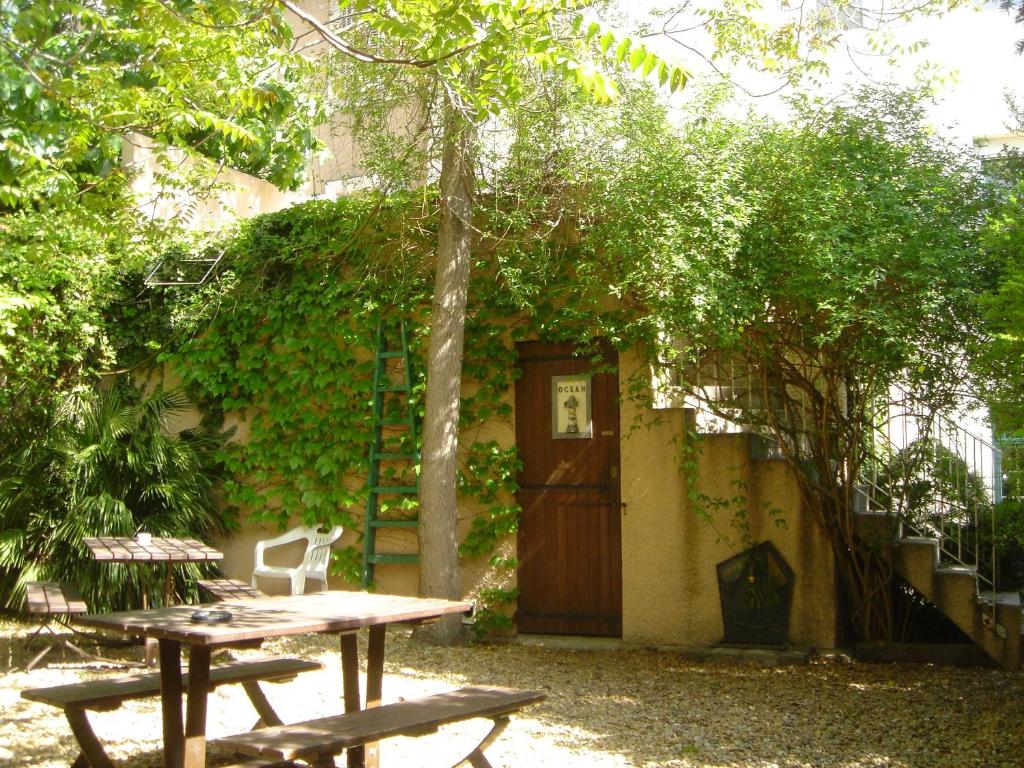 a building with a wooden door and a table and chairs at Résidence Carpe Diem in Marseille