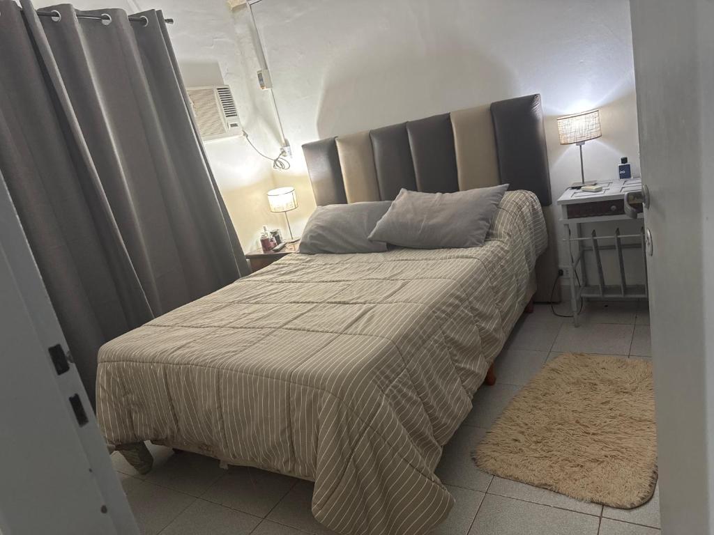 a bedroom with a bed with a gray headboard at Somos Río in La Cruz