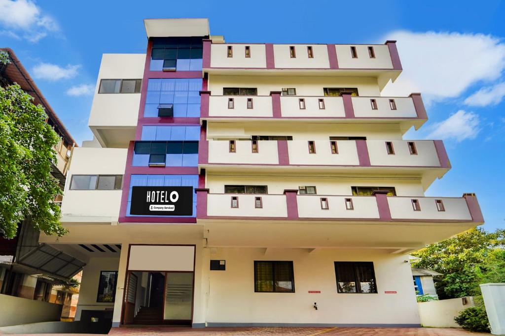 a tall white building with a sign on it at Hotel O Cheranelloor Aster Medicity Formerly Abriz Residency in Cochin