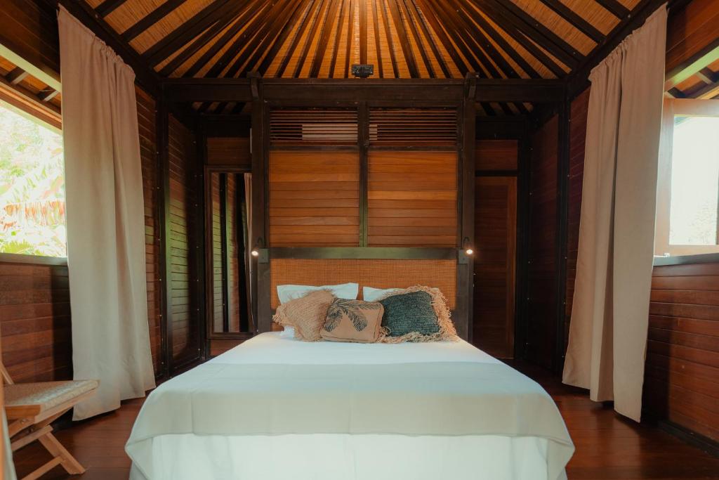 a bedroom with a white bed with a wooden ceiling at Ecolodge Anacardier- Bungalow 2 in Saint-François