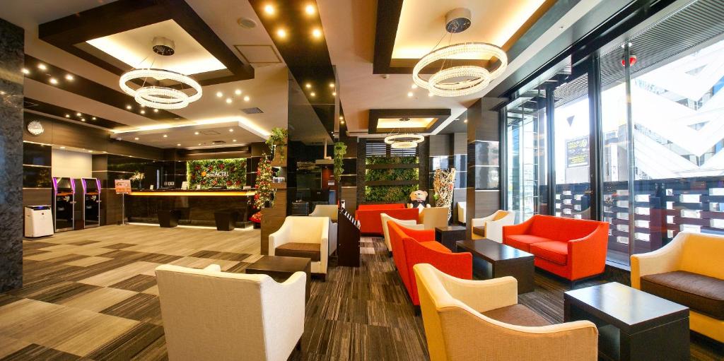 a store lobby with orange and white chairs and windows at Hotel Actel Nagoya Nishiki in Nagoya