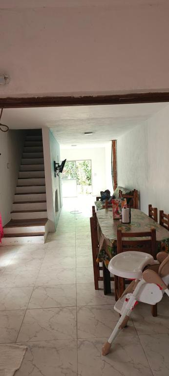 a room with a staircase and a table and a stair case at Casa in San Clemente del Tuyú