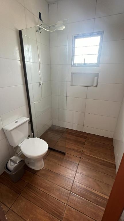 Un baño blanco con inodoro y ventana. en Ranchinho Serra do Cipó, en Jaboticatubas