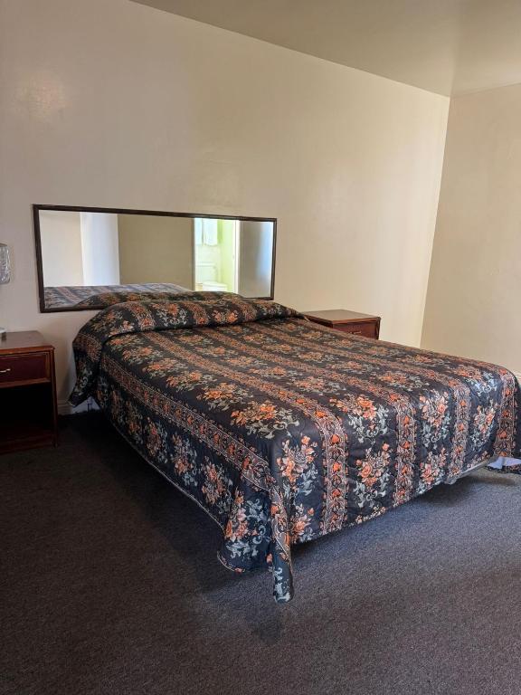 a bedroom with a bed with a large mirror at El Rancho Motel, Pasadena in Pasadena
