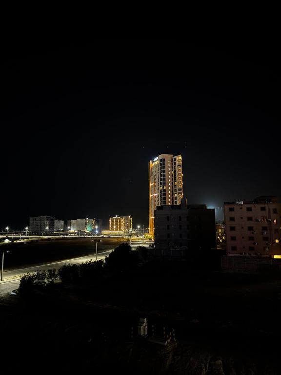 a city skyline at night with a tall building at استديو ديار in Al Khobar