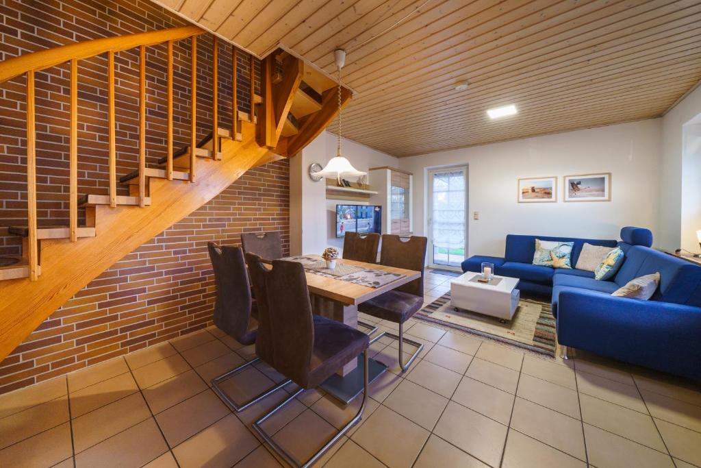 a living room with a blue couch and a table at Achtern Diek 28A in Otterndorf