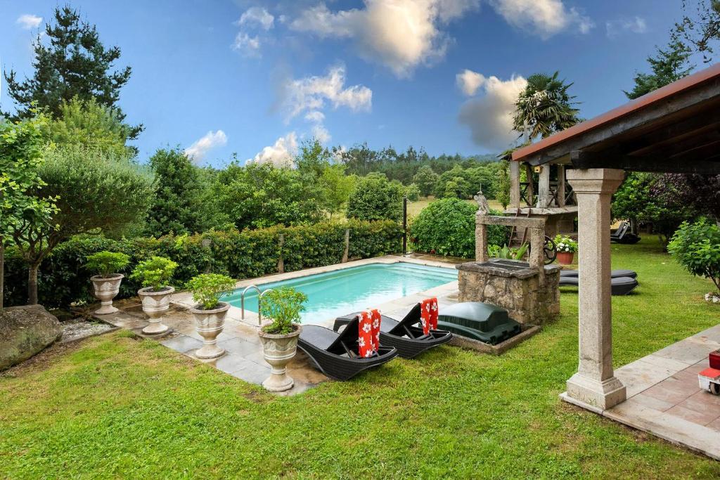 a backyard with a swimming pool and a gazebo at Casa Dos Pazos in Brion