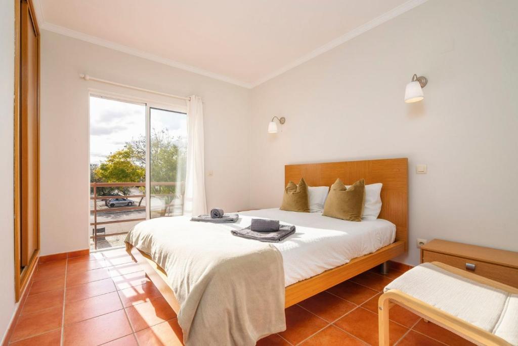 a bedroom with a large bed and a window at Cabanas Beach Apartment in Cabanas de Tavira