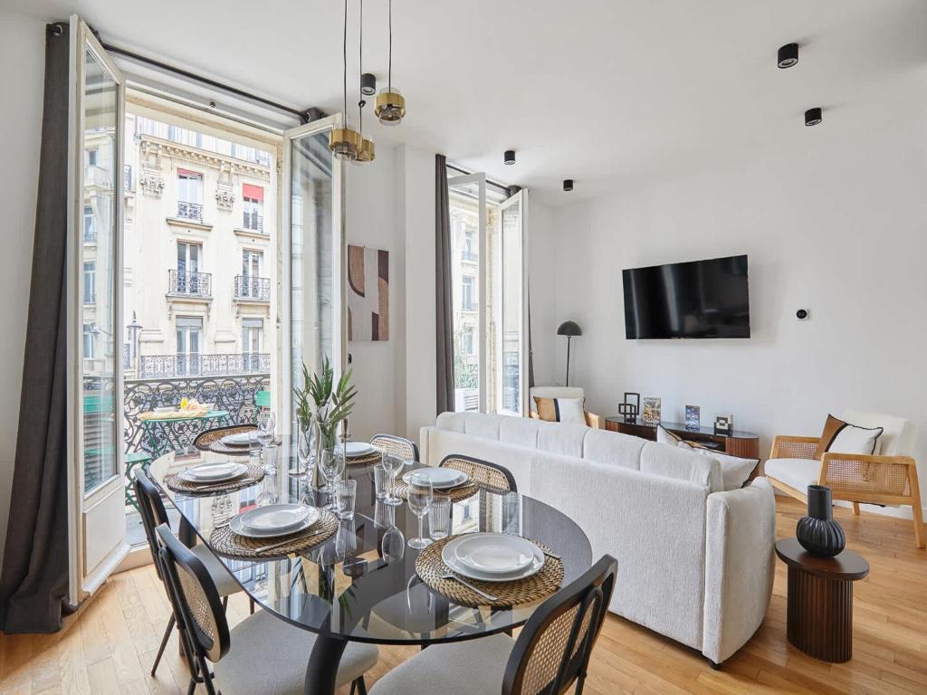 une salle à manger avec une table et un canapé dans l'établissement Magnificent New Apartment Beaubourg Le Marais, à Paris