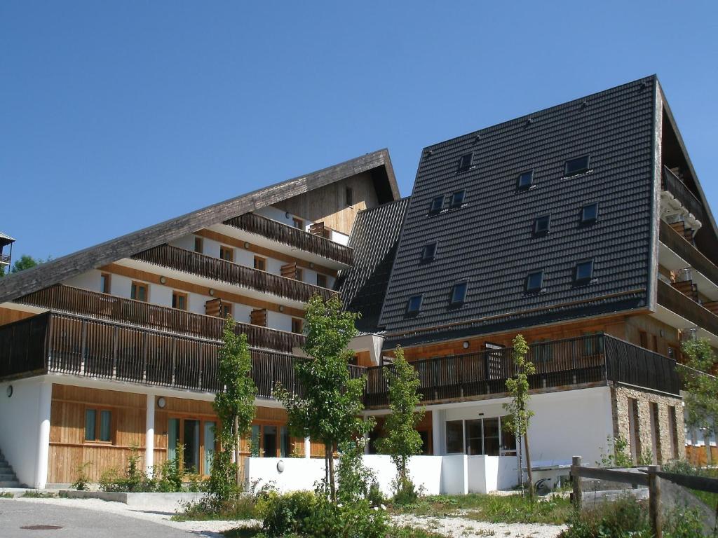 un immeuble d'appartements avec un toit noir dans l'établissement Chalet in Gresse-en-Vercors near Ski Slopes, à Gresse-en-Vercors