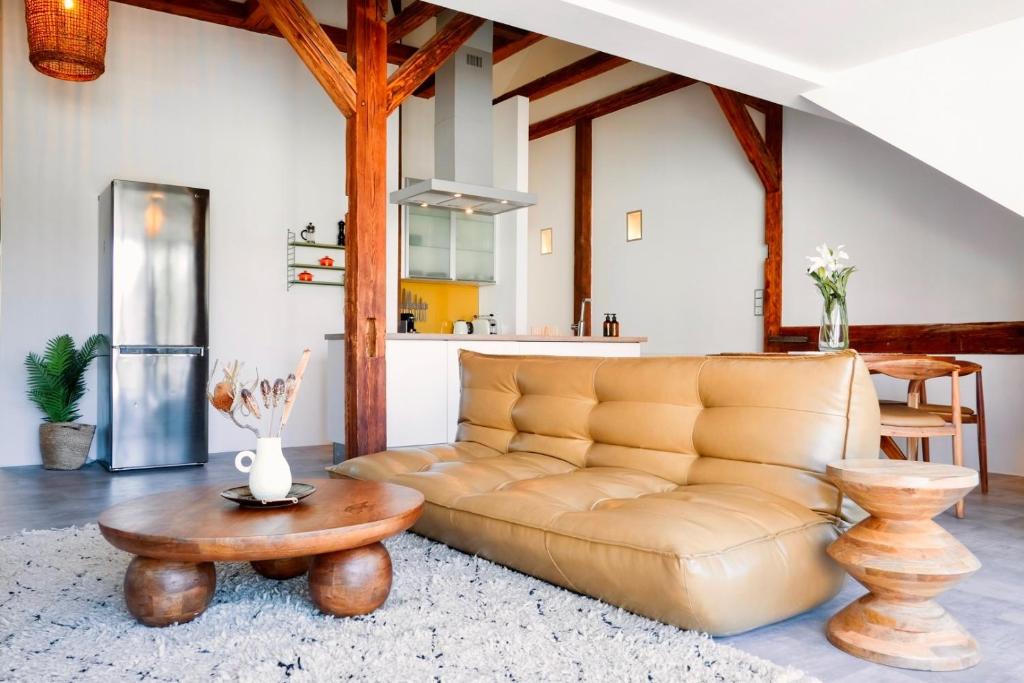 een woonkamer met een bank en een tafel bij Helles Design-Loft im Zentrum mit Schlossbergblick in Graz