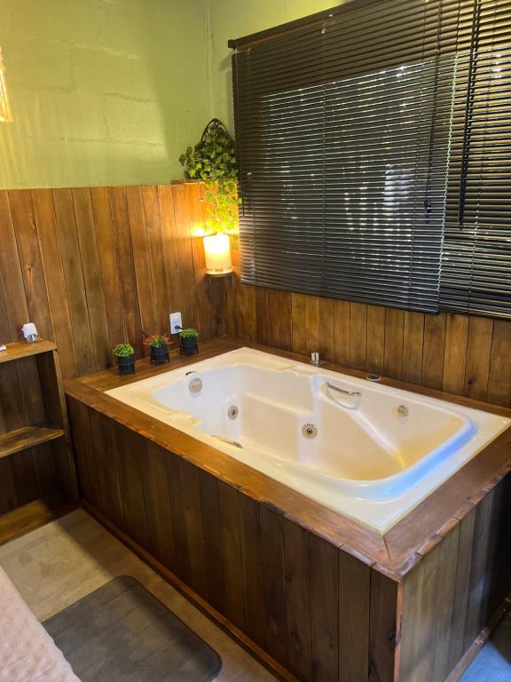 eine große Badewanne in einem Raum mit Fenster in der Unterkunft Mandala Camping Pousada in Florianópolis