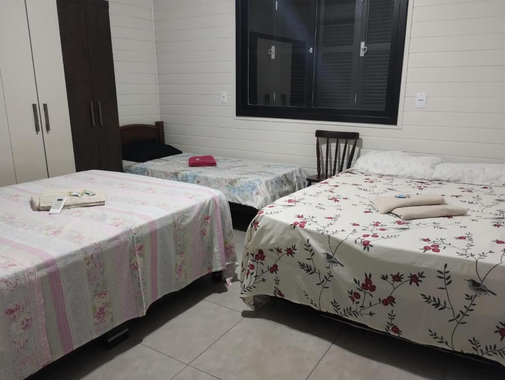 2 letti in una camera con lenzuola rosa e bianche di Hospedagem Pantano Grande a Pântano Grande