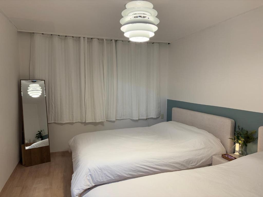 una camera da letto con un letto bianco e una finestra di 7pp aloha stay OlympicPark KSPO JYP LotteWorld a Seul