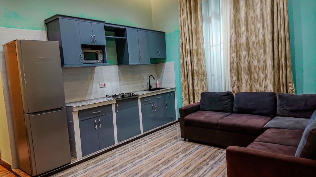 a living room with a couch and a kitchen at RJ's Apartments Korogwe in Korogwe