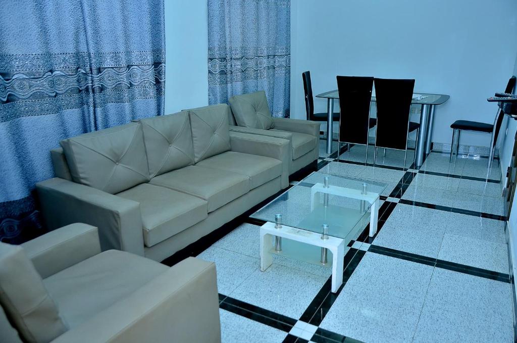 a living room with a couch and a glass table at Gosen House Zanguéra in Ablogbé