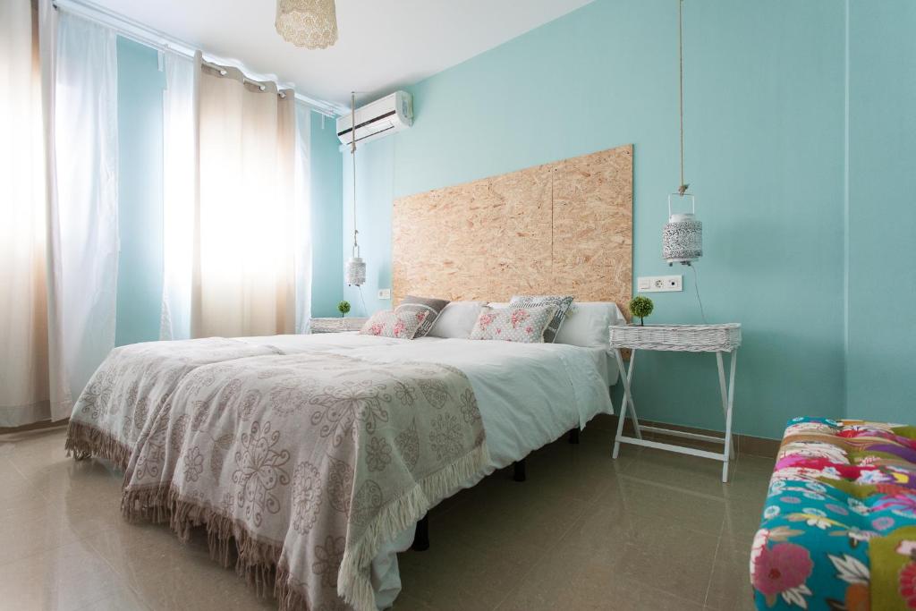 Un dormitorio azul con una cama grande y una mesa en Apartamentos Alberto Lista 9, en Sevilla