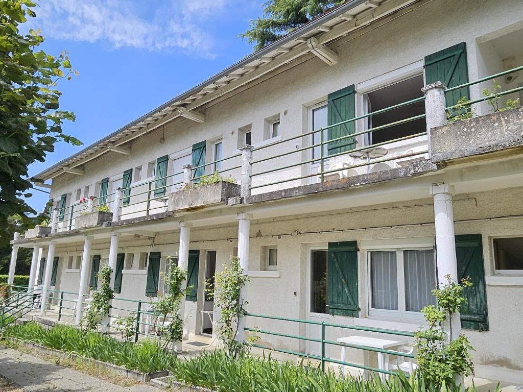 - un bâtiment blanc avec des fenêtres et des balcons dans l'établissement Studio cosy avec balcon, jardin, WIFI et stationnement près des Thermes - FR-1-541-114, à La Roche-Posay
