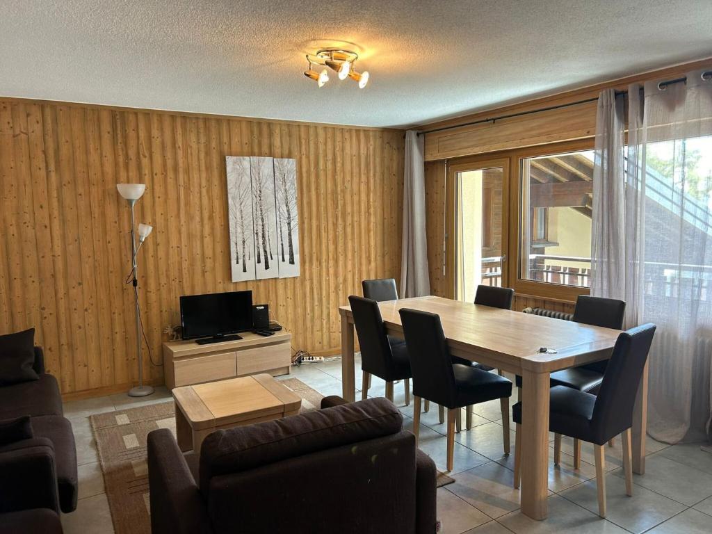 a living room with a dining room table and chairs at Apartment Veysonnaz near Ski Lift 4 Vallées in Veysonnaz
