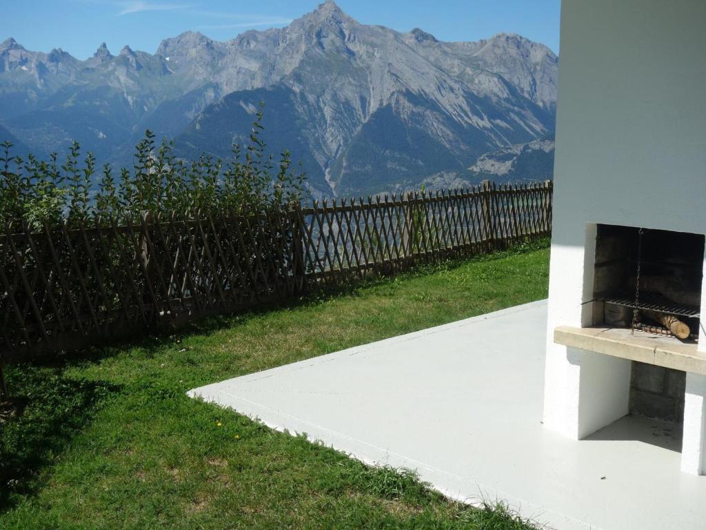 a cat sitting on a bench with a view of mountains at Apartment in Veysonnaz with Private Balcony in Veysonnaz