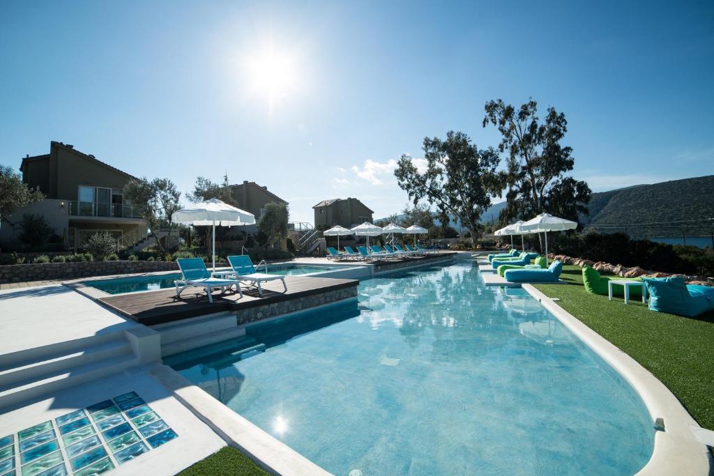 a large swimming pool with chairs and umbrellas at Lavender Cove in Korfos