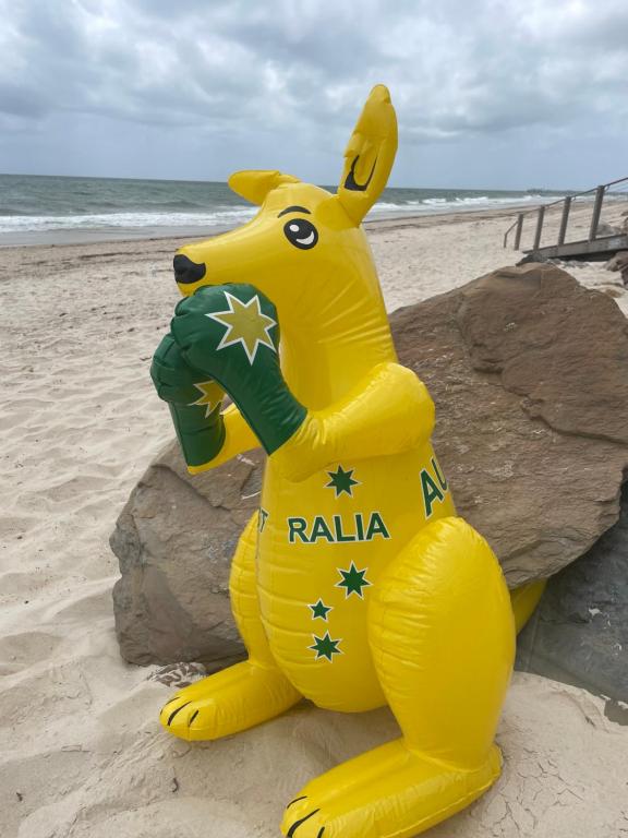 a large yellow inflatable dog sitting on the beach at Adelaide Style Accommodation-Getaway in North Adelaide- close to city in Adelaide